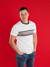 Handsome young man posing on red background