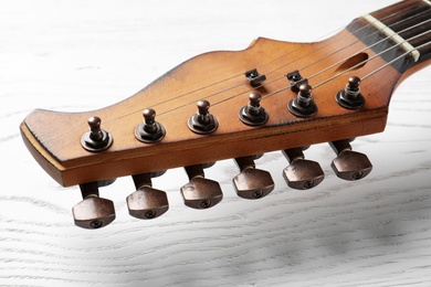 Photo of Modern electric guitar on wooden background, closeup view. Musical instrument