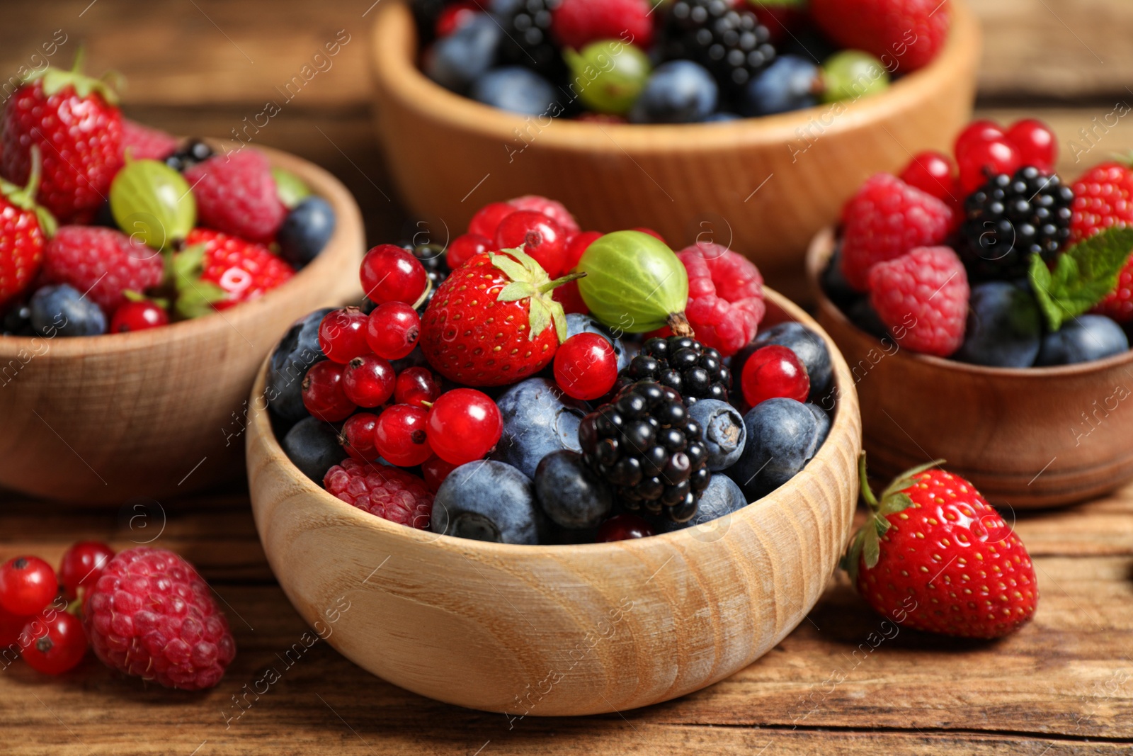 Photo of Mix of ripe berries on wooden table, closeup