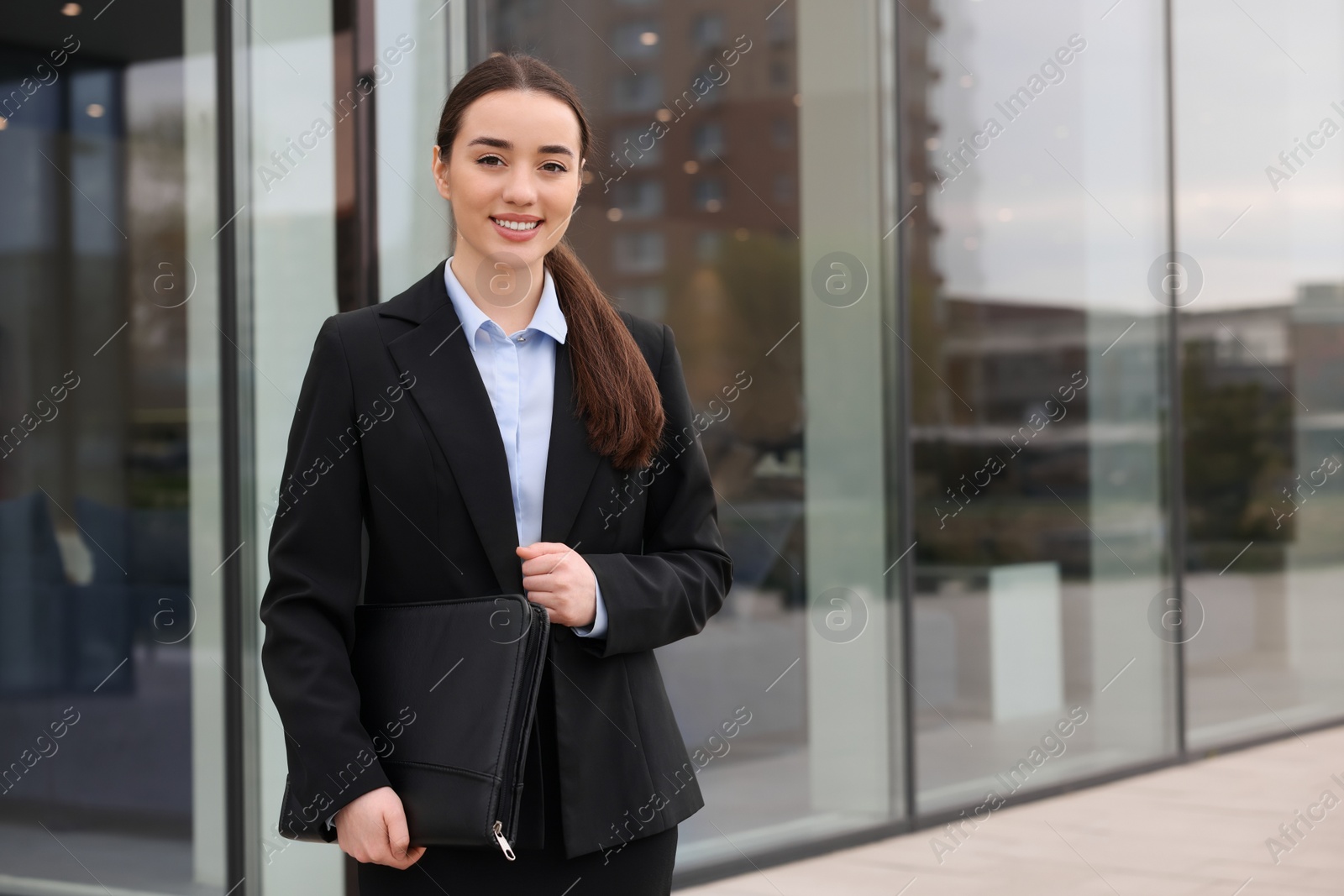 Photo of Real estate agent with leather portfolio outdoors. Space for text