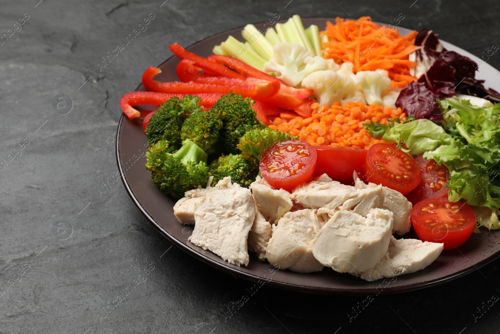 Photo of Balanced diet and healthy foods. Plate with different delicious products on black table, closeup