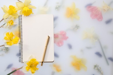 Photo of Guest list. Notebook, pen and daffodils on spring floral background, flat lay. Space for text