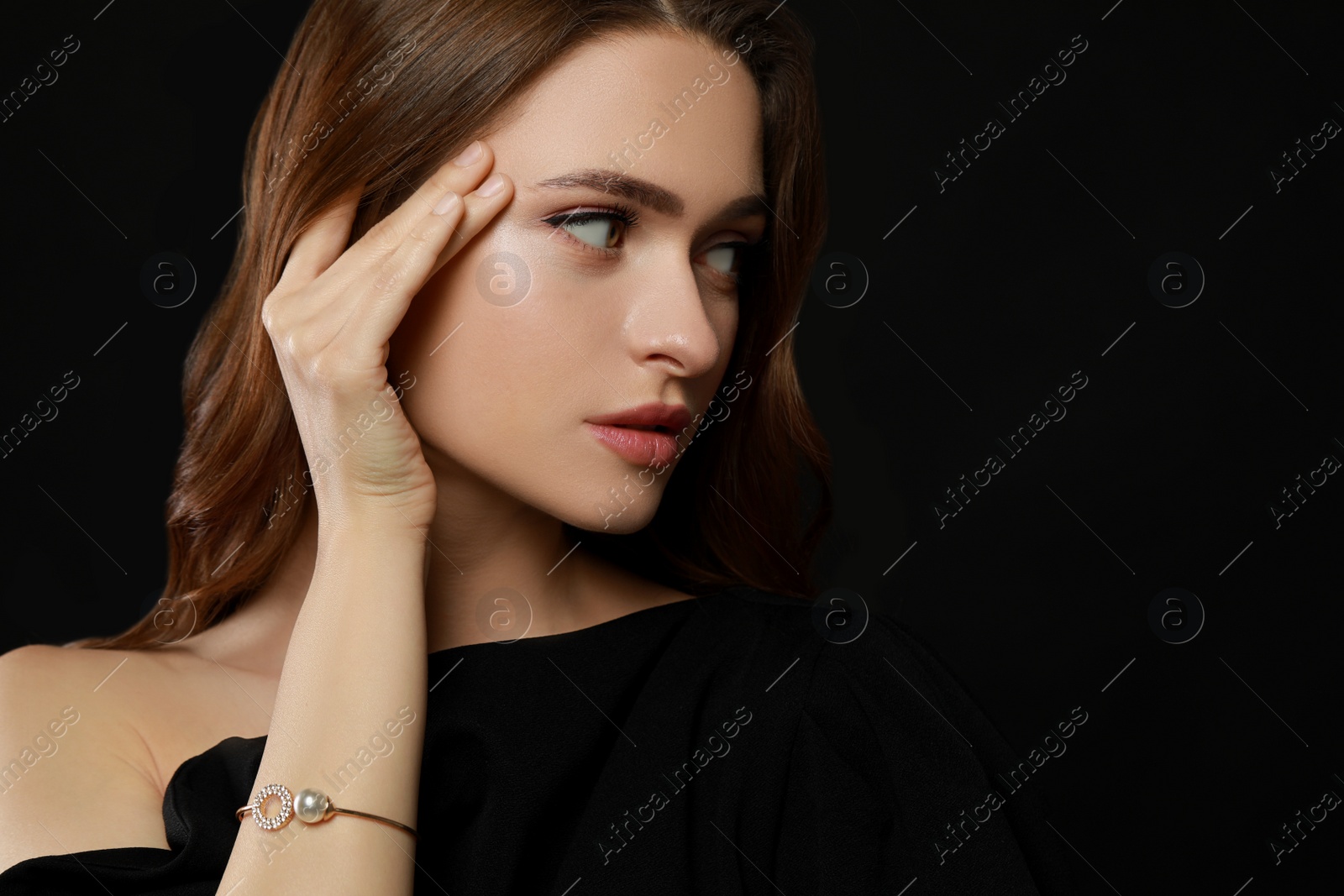 Photo of Young woman wearing elegant pearl bracelet on black background, space for text