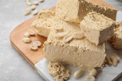 Photo of Pieces of tasty halva on light gray table, closeup