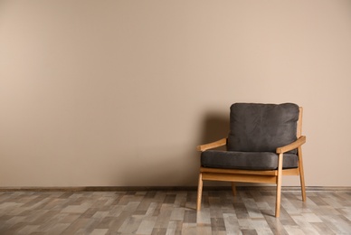 Stylish chair near color wall, space for text. Interior design