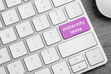 Modern computer keyboard with text MATERNITY LEAVE on table, closeup