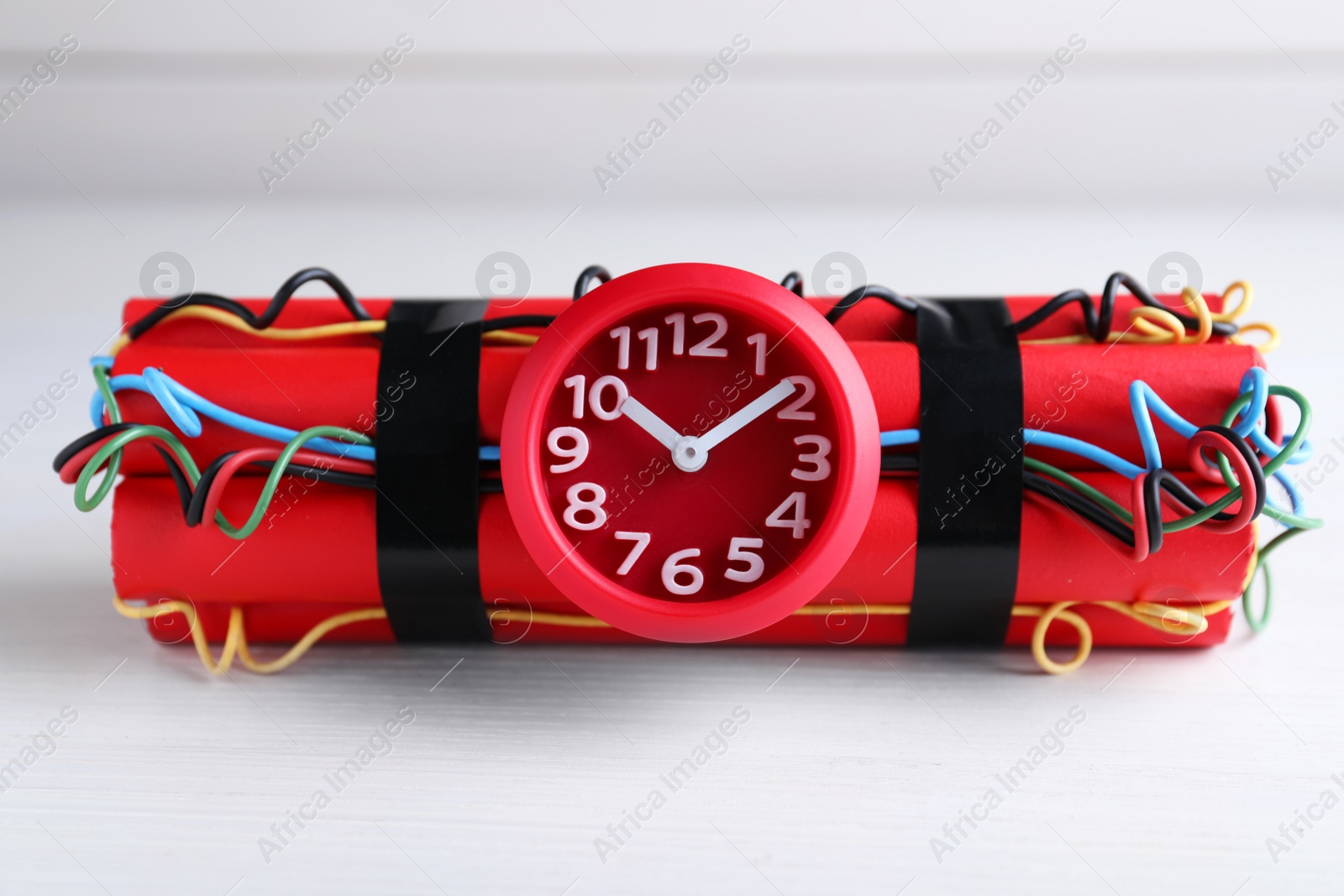 Photo of Explosive dynamite time bomb on white wooden background