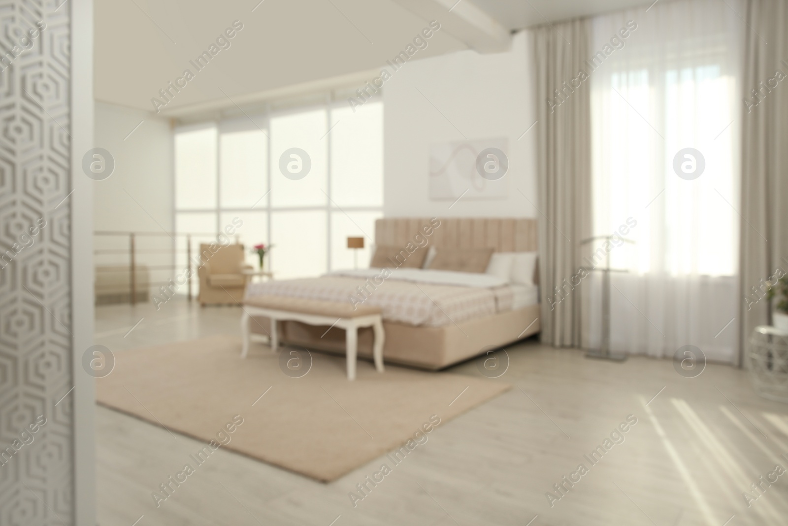 Photo of Blurred view of stylish hotel bedroom interior with modern furniture