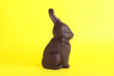 Dark chocolate Easter bunny with bite mark on yellow background