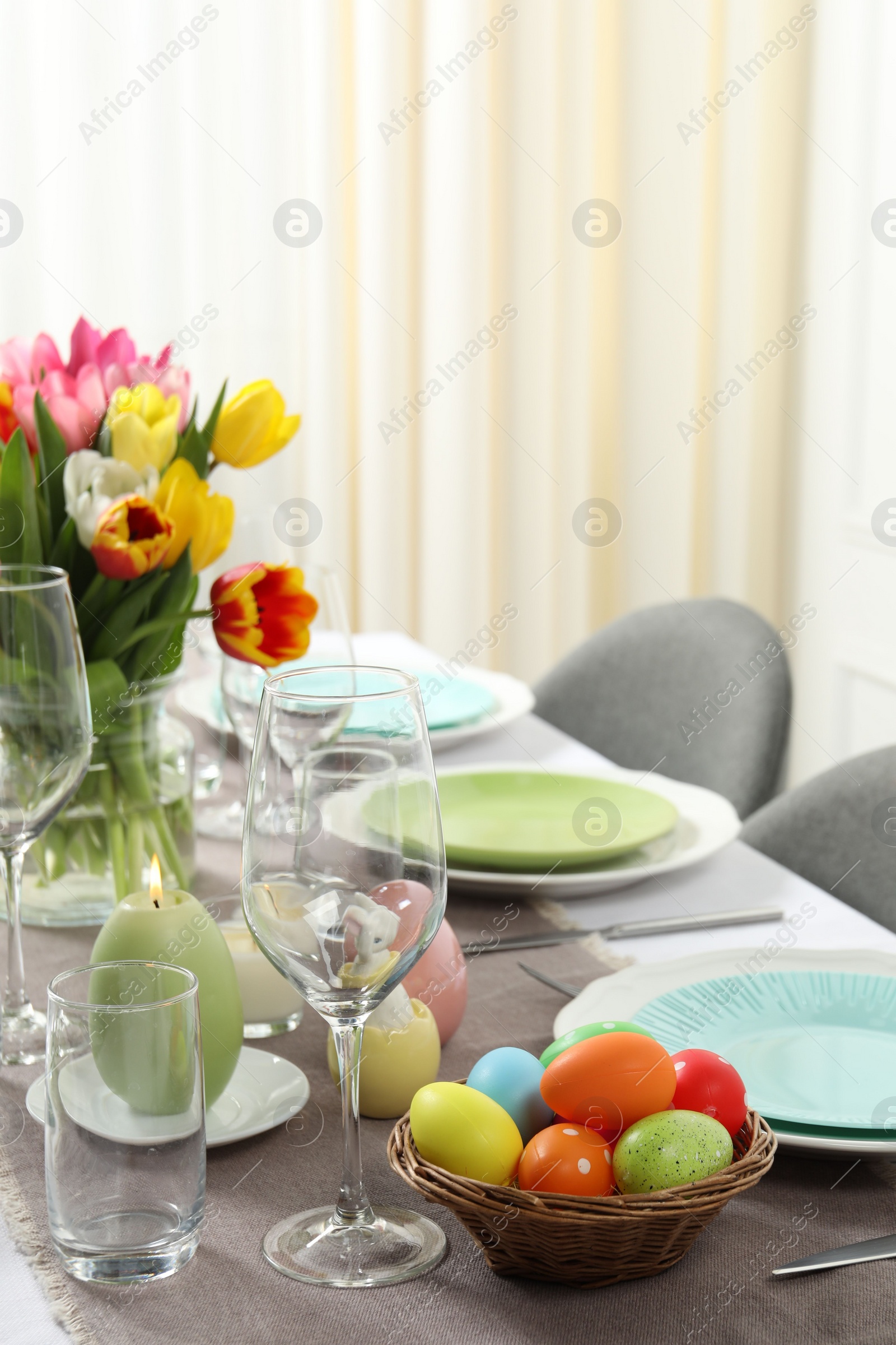 Photo of Easter celebration. Festive table setting with beautiful flowers and painted eggs