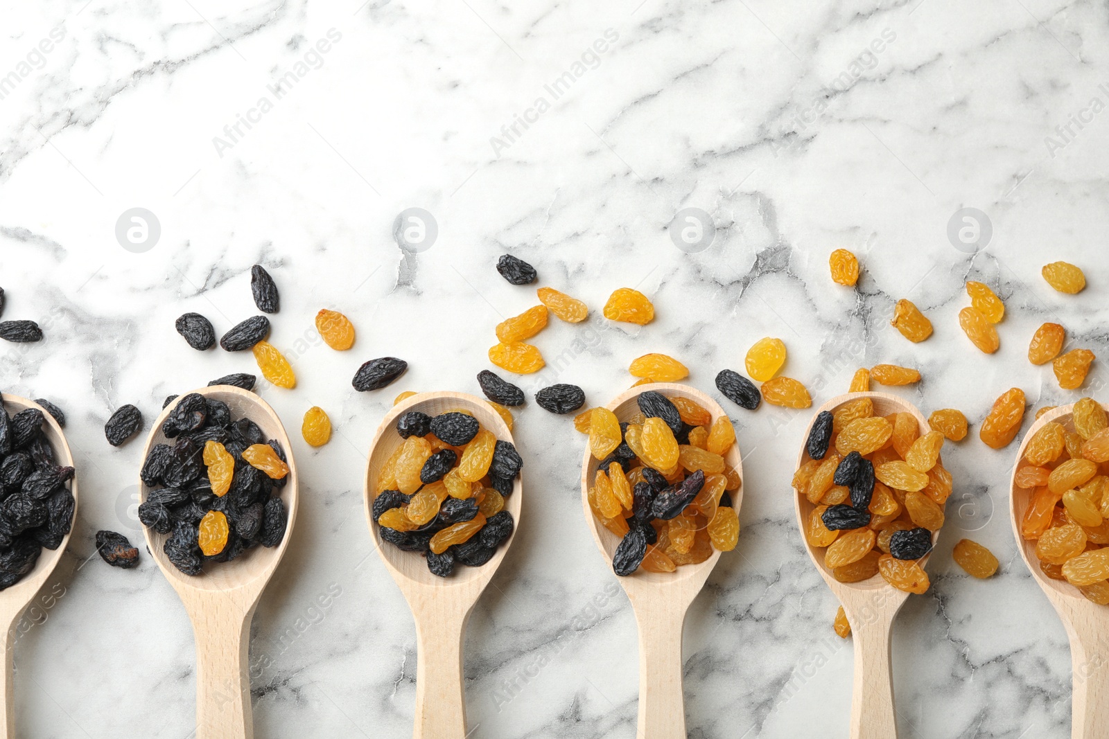 Photo of Flat lay composition with raisins on marble background. Dried fruit as healthy snack