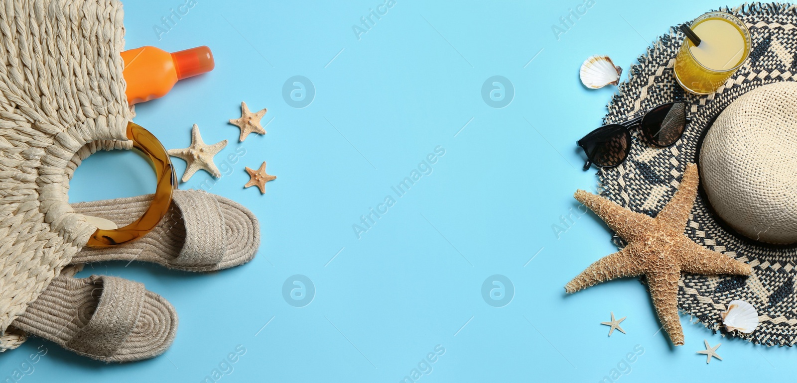 Photo of Beach accessories and space for text on light blue background, flat lay. Banner design