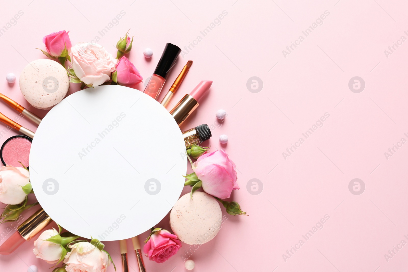 Photo of Flat lay composition with card and products for decorative makeup on pastel pink background