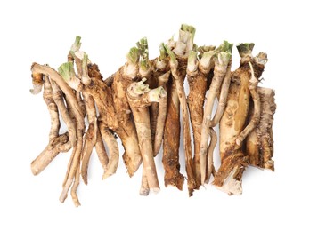 Photo of Pile of fresh horseradish roots isolated on white, top view