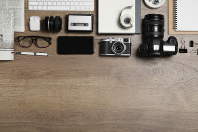 Photo of Flat lay composition with equipment for journalist on wooden table. Space for text