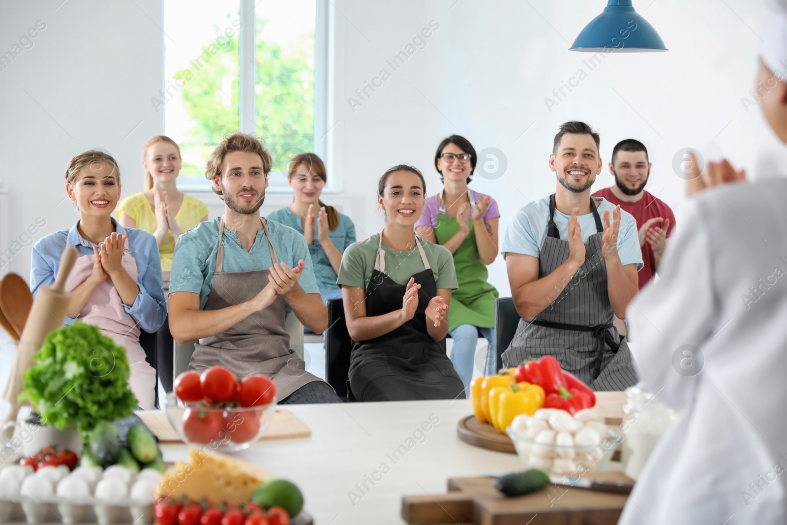 Photo of Group of people and female chef at cooking classes