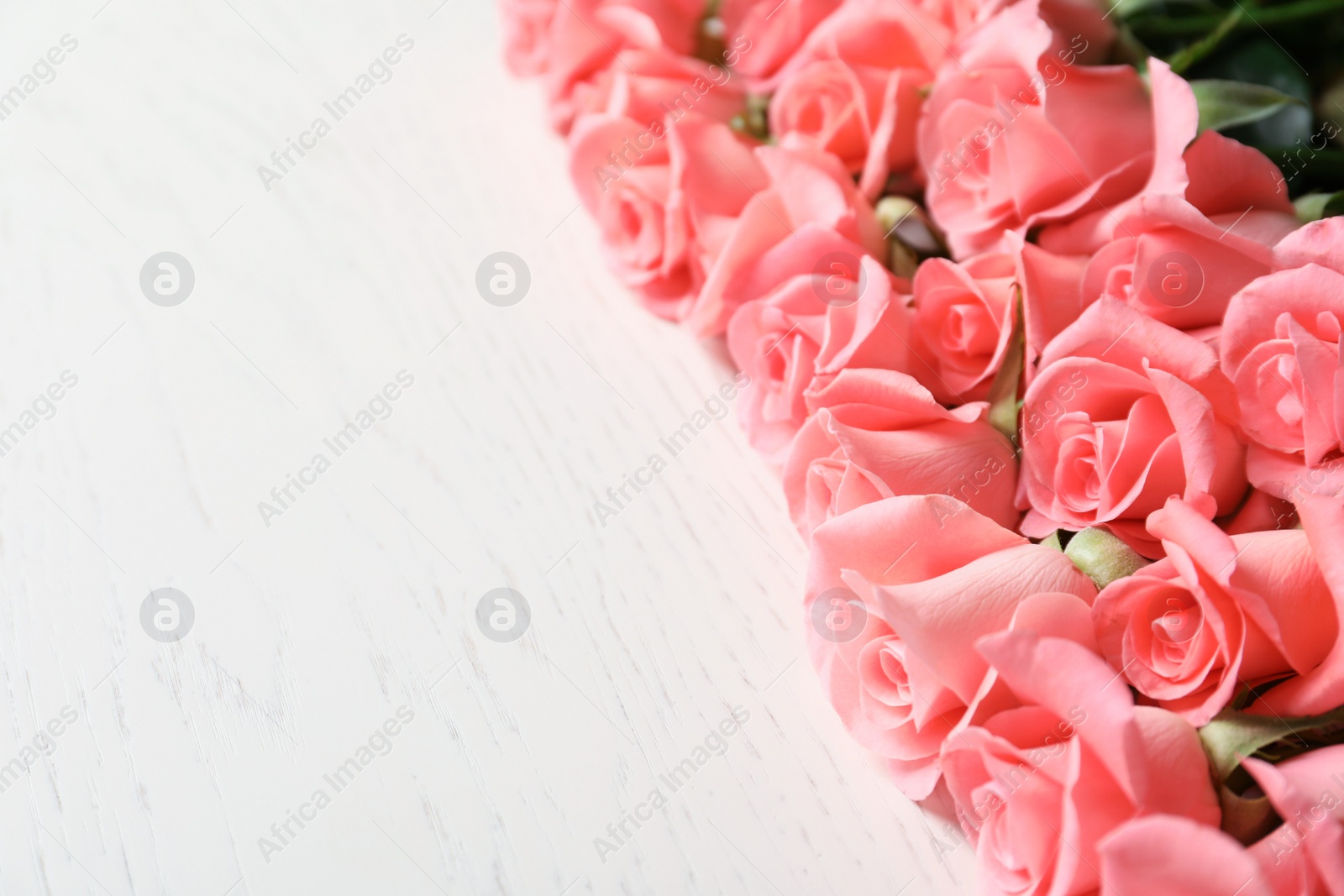 Photo of Beautiful roses on wooden table