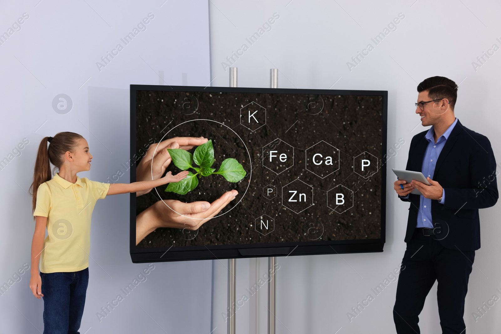 Photo of Teacher and pupil using interactive board in classroom during lesson