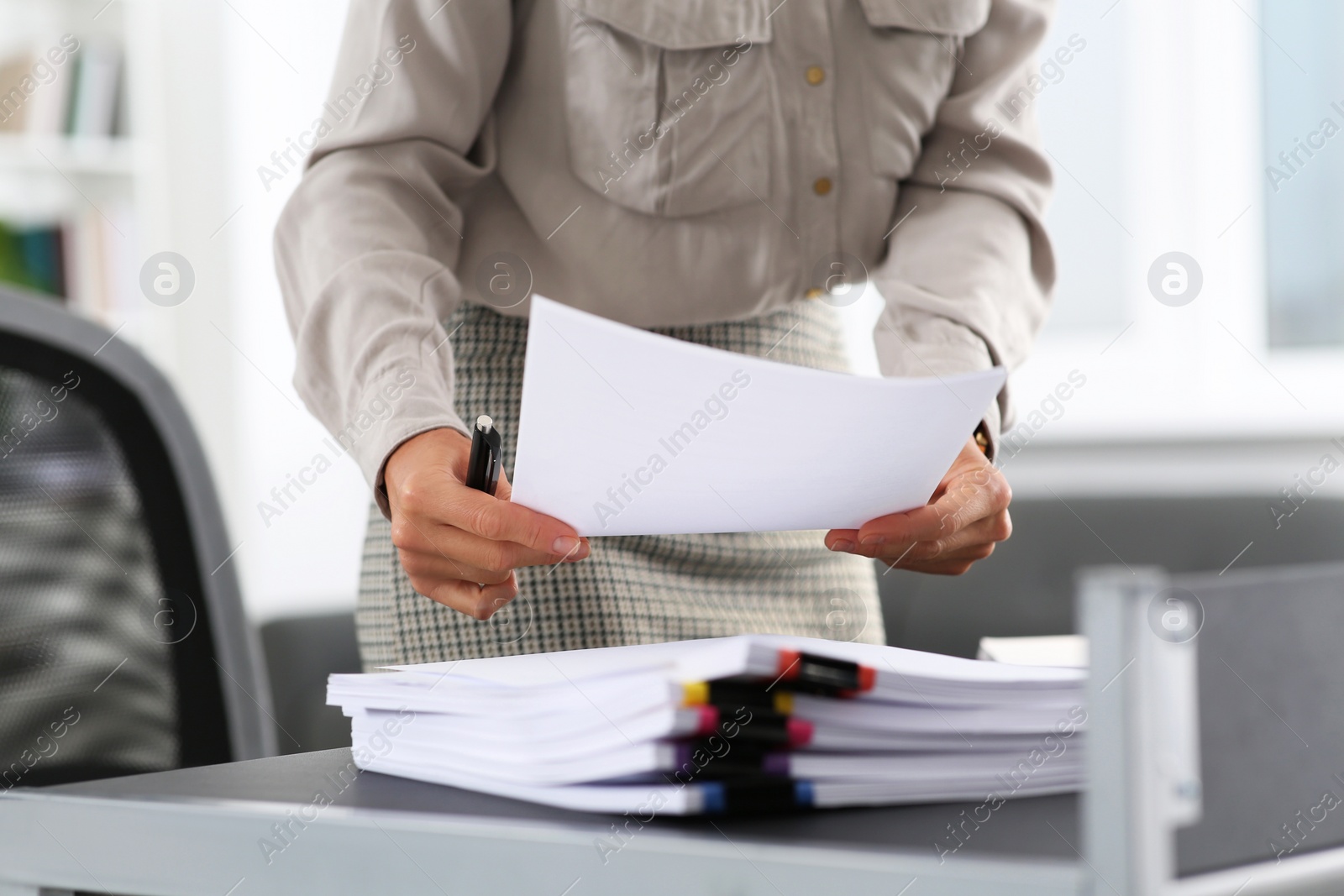 Photo of Businesswoman with documents near table in office, closeup