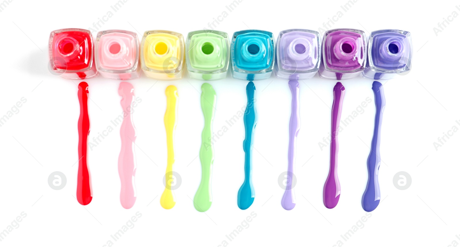 Photo of Spilled colorful nail polishes and bottles on white background, top view