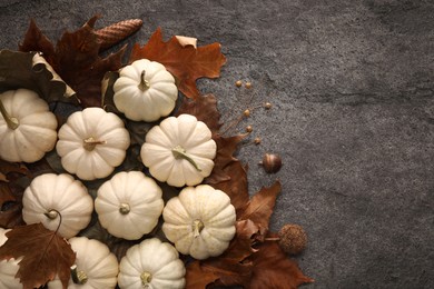 Flat lay composition with ripe pumpkins on grey textured table. Space for text