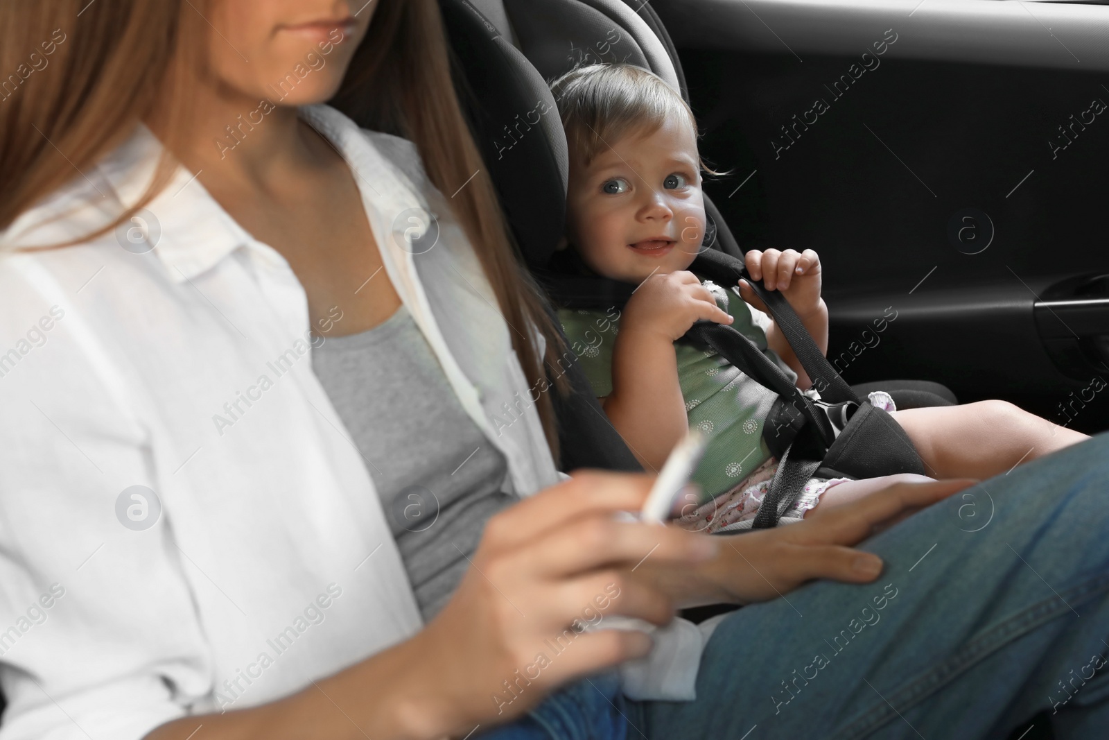 Photo of Mother with cigarette and child in car, closeup. Don't smoke near kids