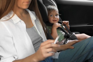 Photo of Mother with cigarette and child in car, closeup. Don't smoke near kids