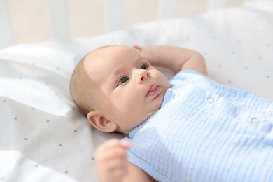 Cute little baby lying in crib at home