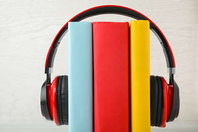 Photo of Books and modern headphones on white background, closeup