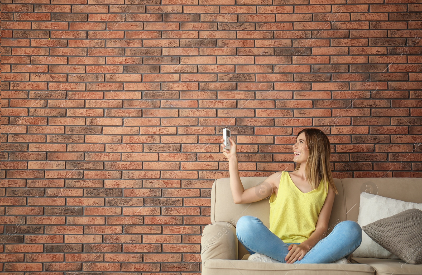 Photo of Woman with air conditioner remote at home