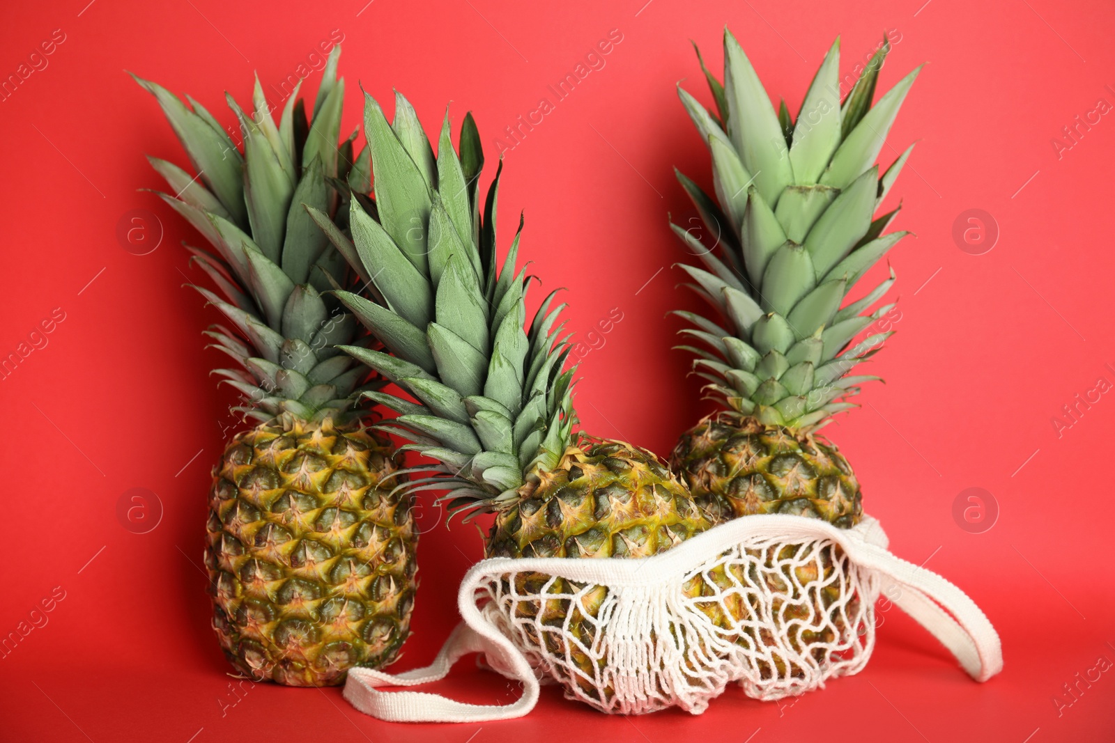 Photo of Fresh ripe juicy pineapples on red background