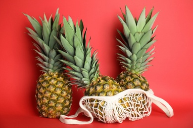 Photo of Fresh ripe juicy pineapples on red background