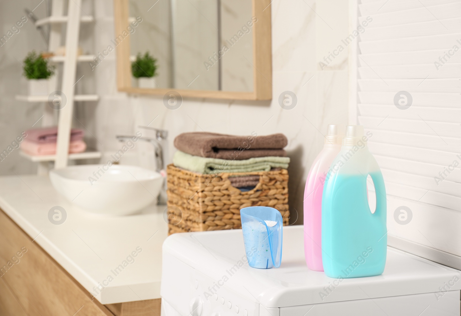 Photo of Different detergents on washing machine in bathroom. Laundry day