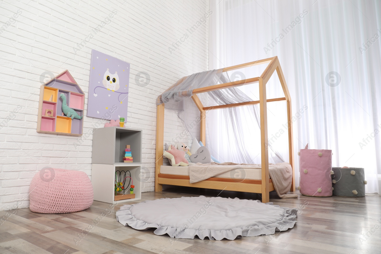 Photo of Cute child's room interior with toys and modern furniture