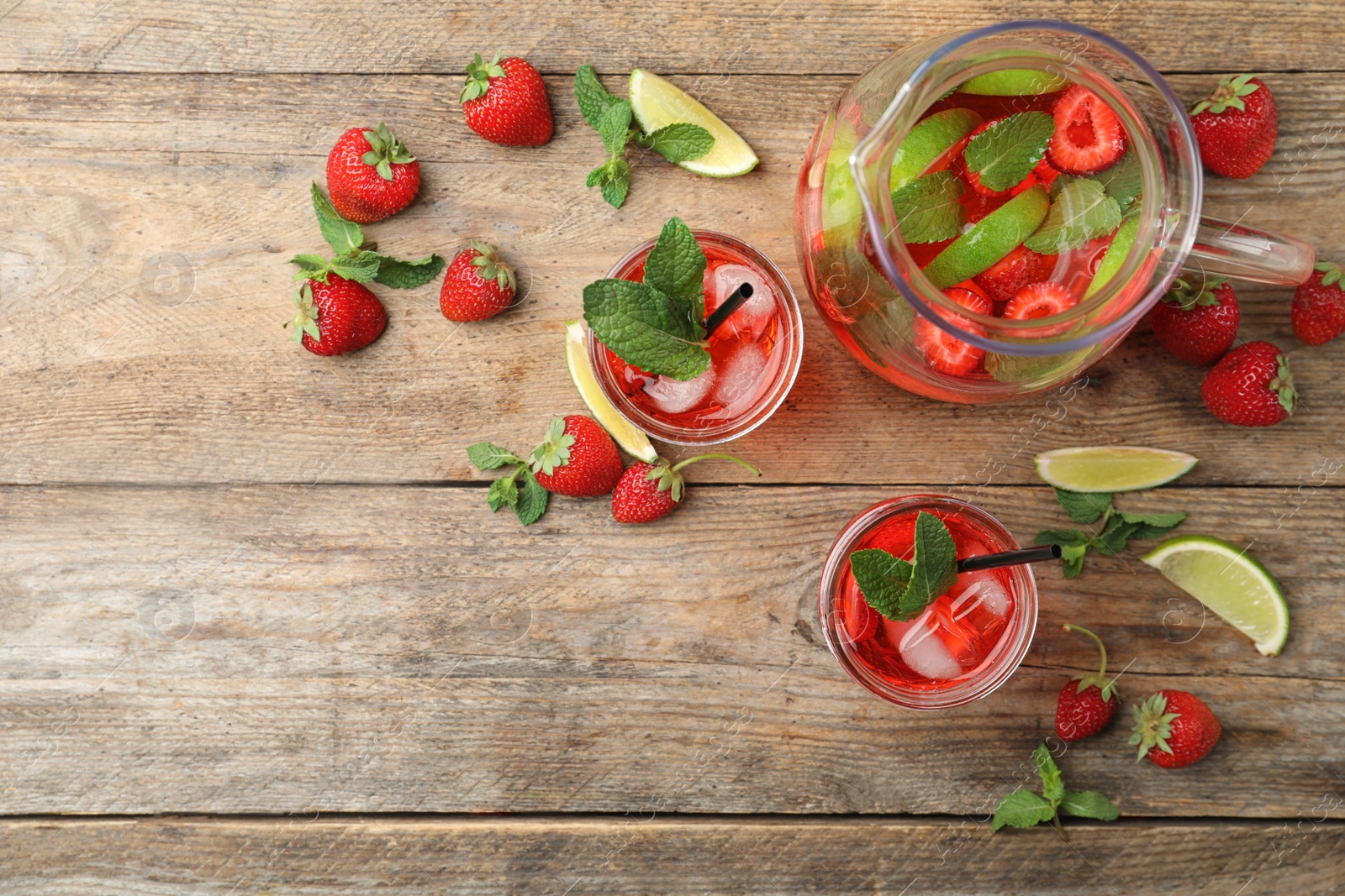 Photo of Refreshing drink with strawberry and lime on wooden table, flat lay. Space for text
