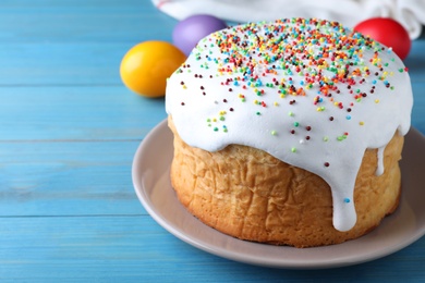 Easter cake and color eggs on blue wooden table, space for text