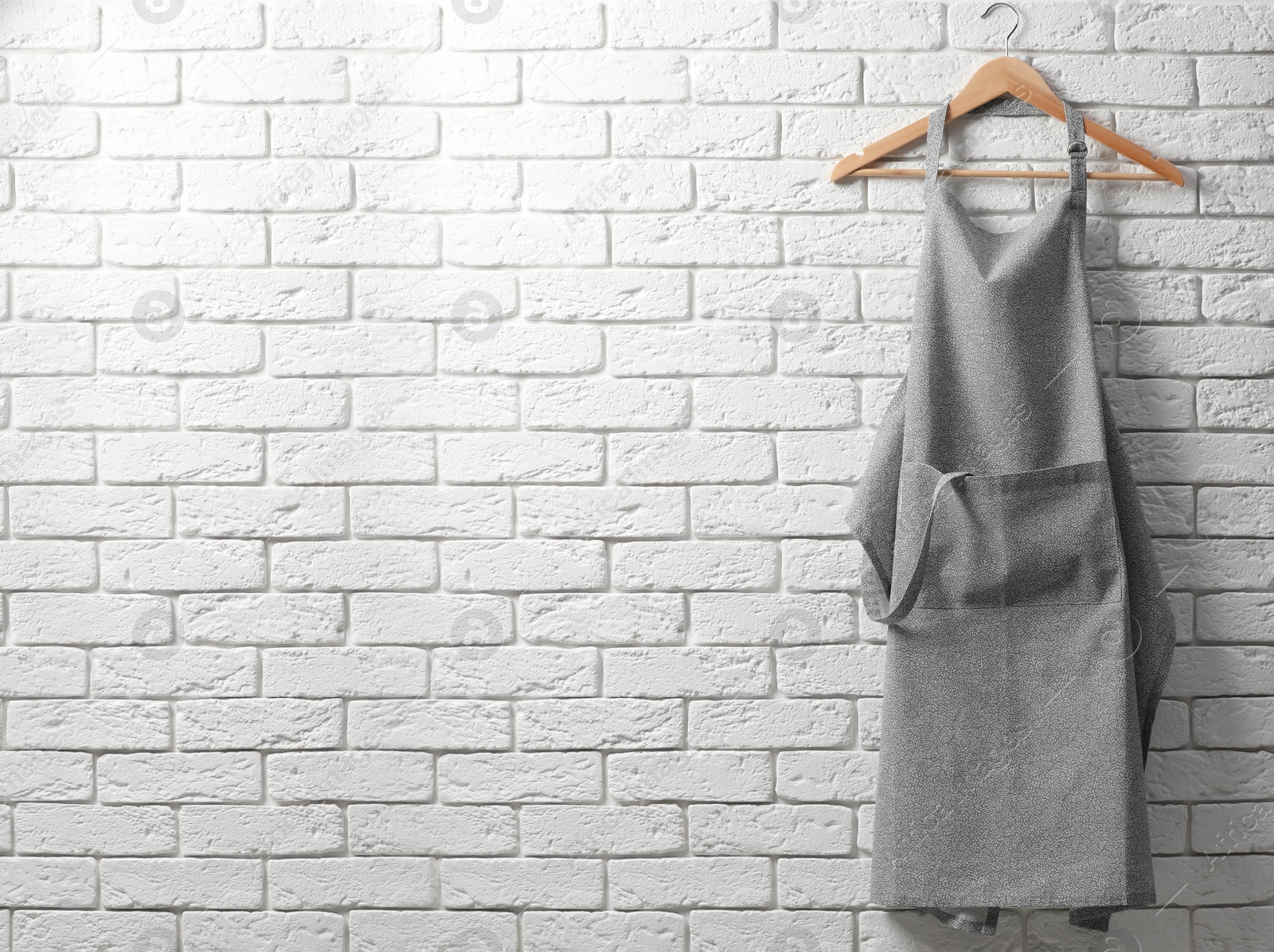 Photo of Clean kitchen apron with pattern on white brick wall. Space for text