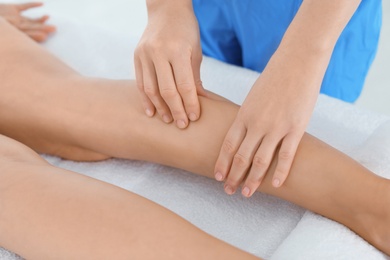 Photo of Woman receiving leg massage in wellness center, closeup