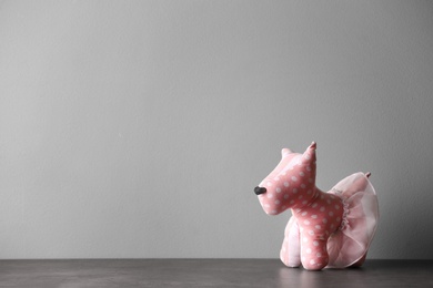 Photo of Abandoned toy dog on table against light background. Time to visit child psychologist