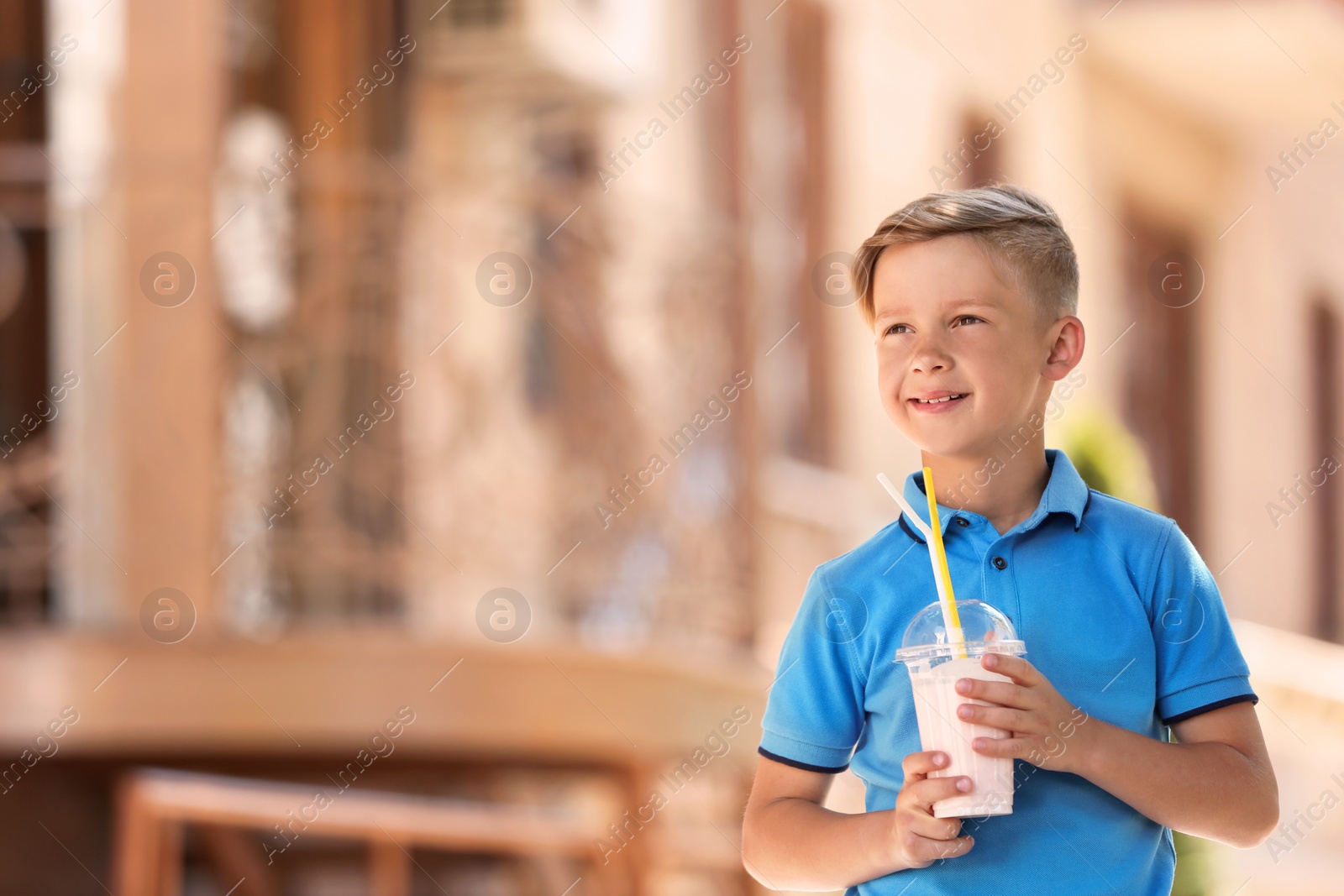 Photo of Little boy with cup of milk shake outdoors