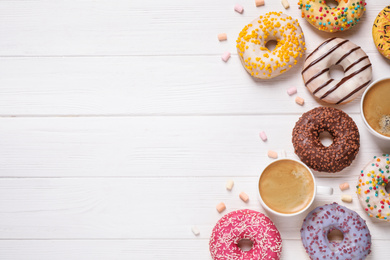 Photo of Flat lay composition with yummy donuts on white wooden background, space for text