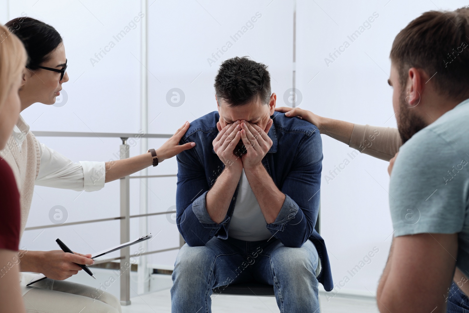 Photo of Psychotherapist working with group of drug addicted people at therapy session indoors