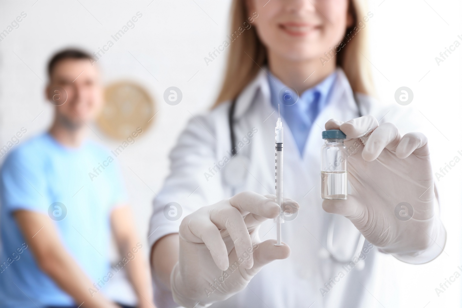 Photo of Doctor holding ampule with vaccine and syringe for patient in clinic