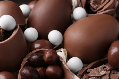 Tasty chocolate eggs and sweets as background, closeup