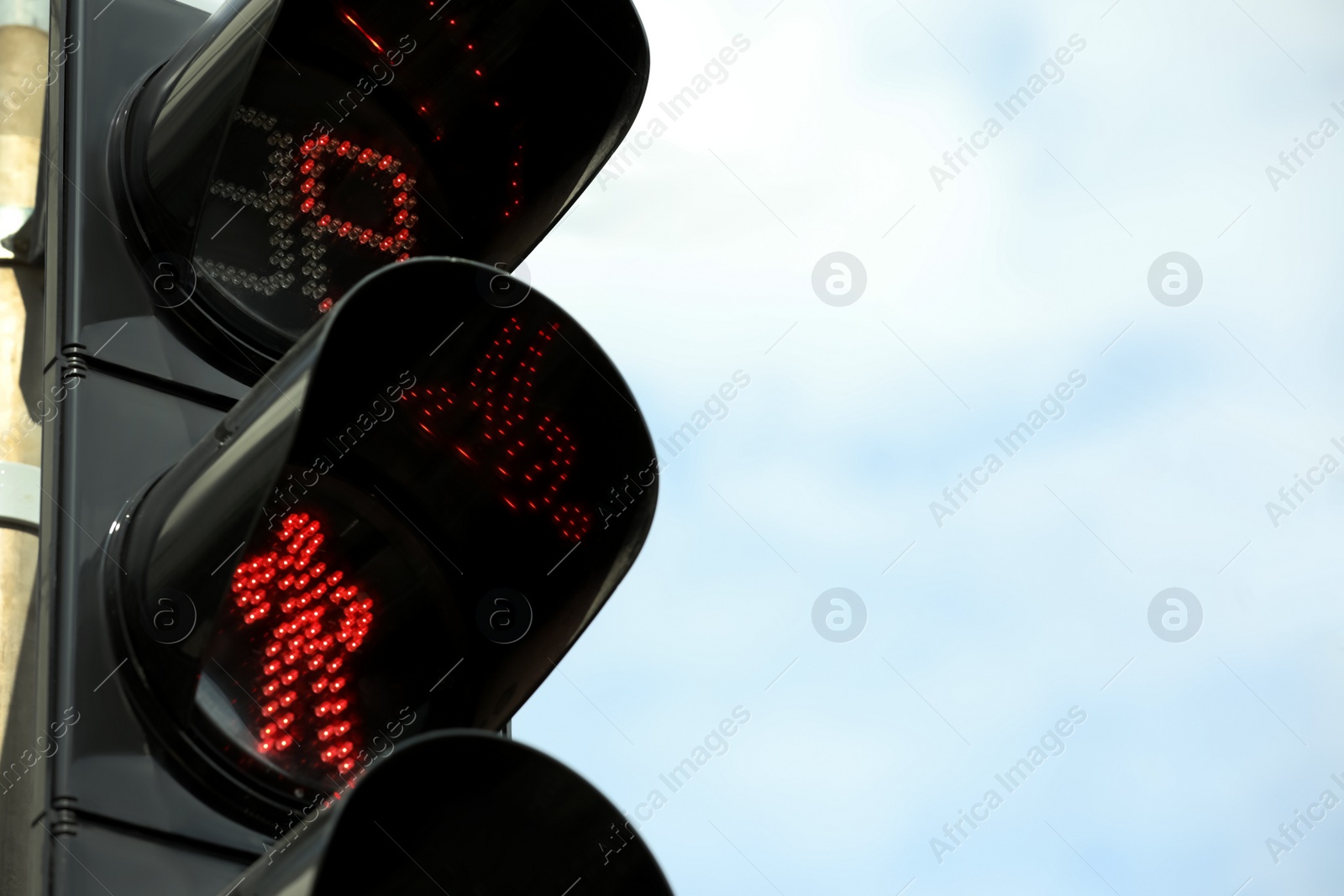 Photo of Closeup view of traffic light against blue sky. Space for text