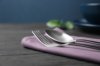 Photo of Cutlery set and dishware on dark wooden table