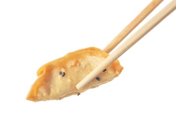 Photo of Chopsticks with delicious gyoza (asian dumpling) and sesame isolated on white