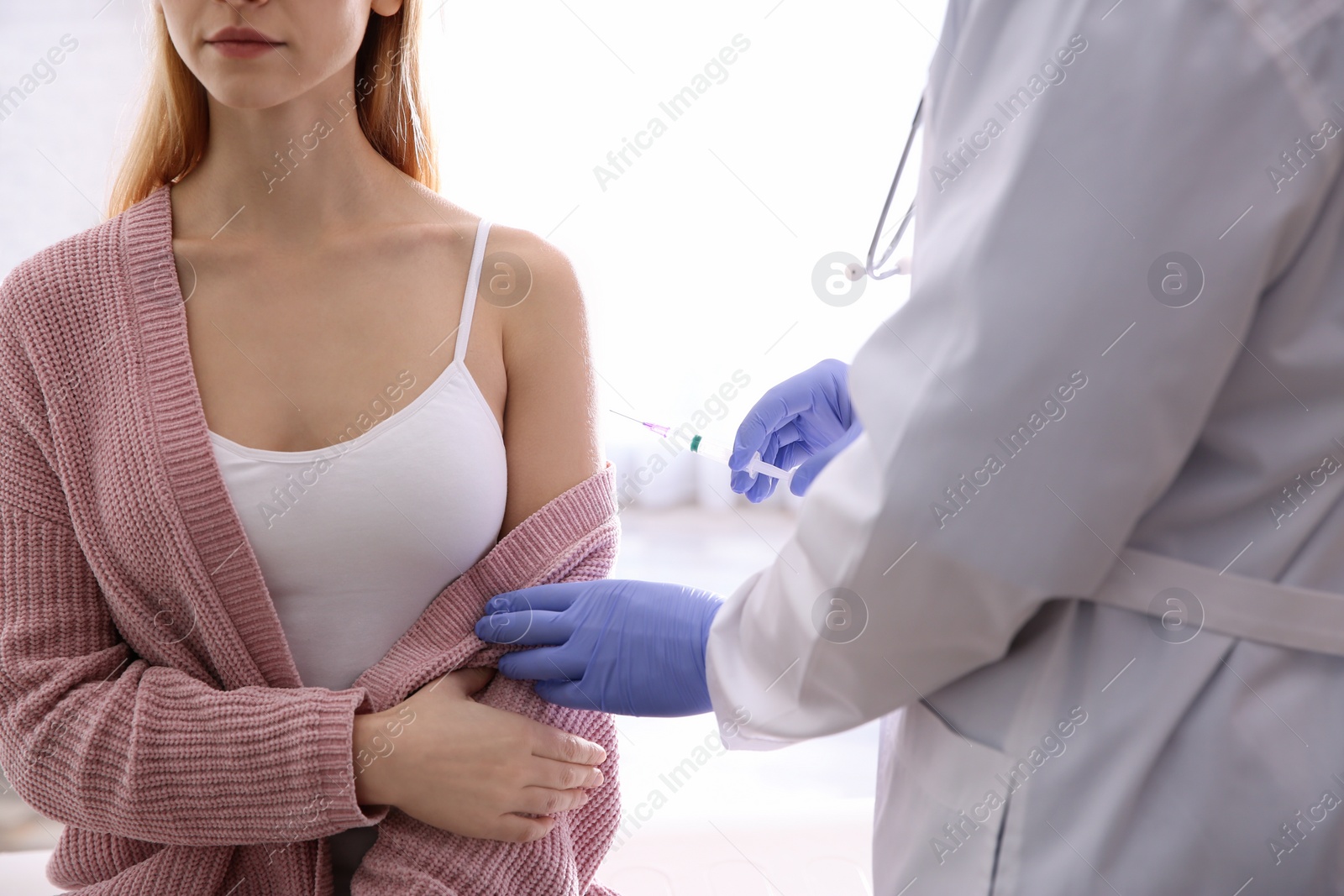 Photo of Doctor giving injection to patient in hospital, closeup. Vaccination concept