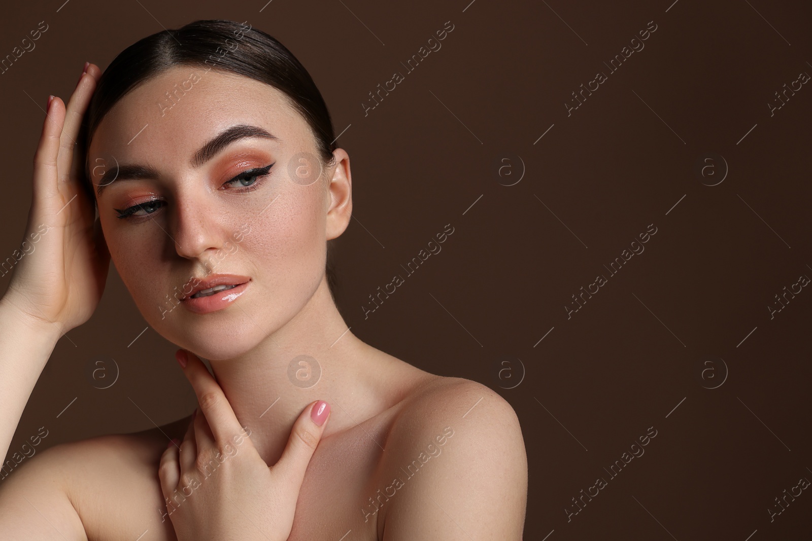 Photo of Portrait of beautiful woman with fake freckles on brown background. Space for text