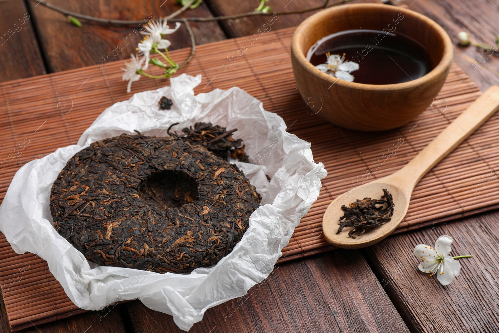 Photo of Composition with aromatic pu-erh tea on wooden table, closeup